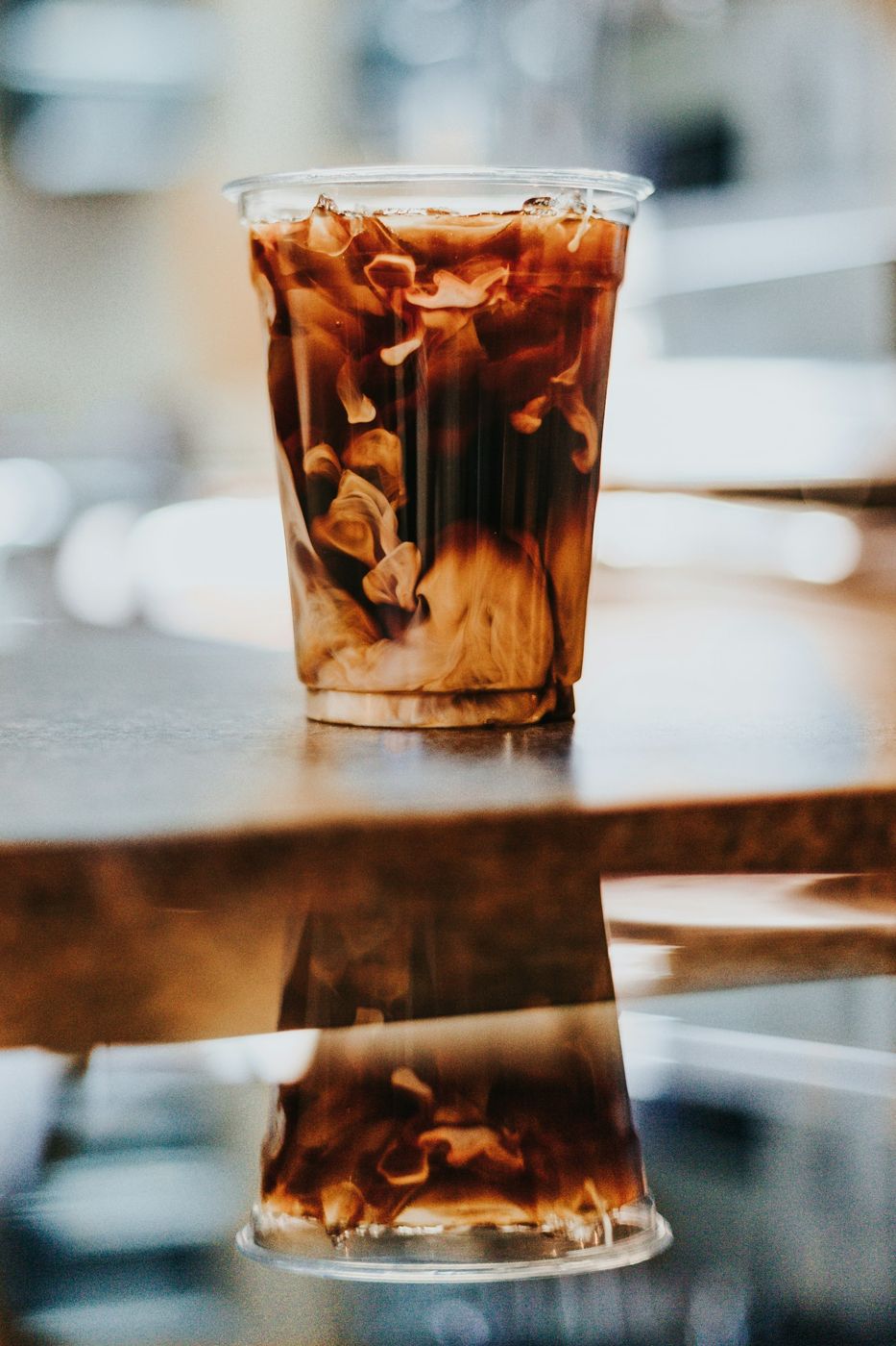 Iced coffee in a clear glass on a reflective counter
