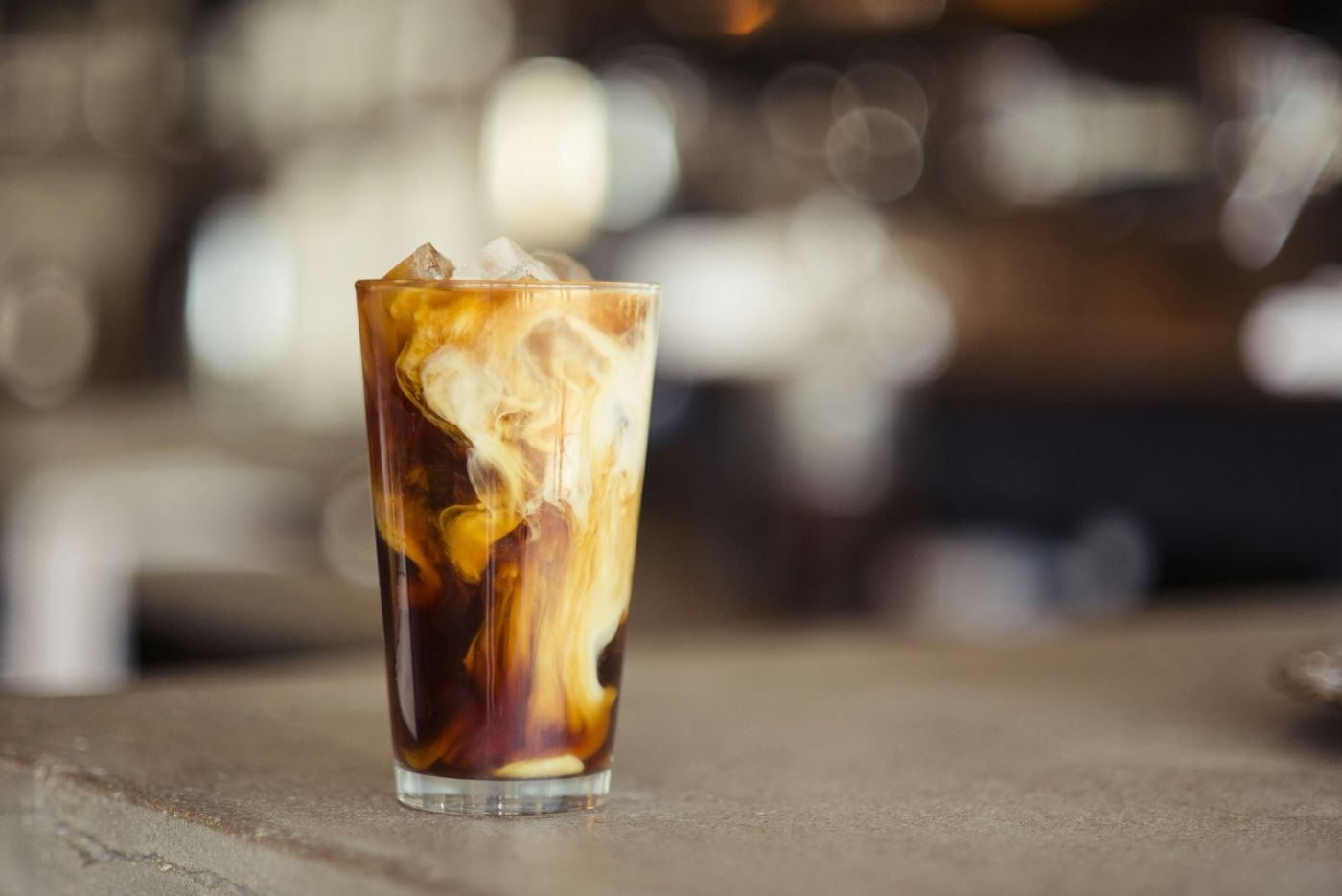 An iced latte in a glass on a tabletop