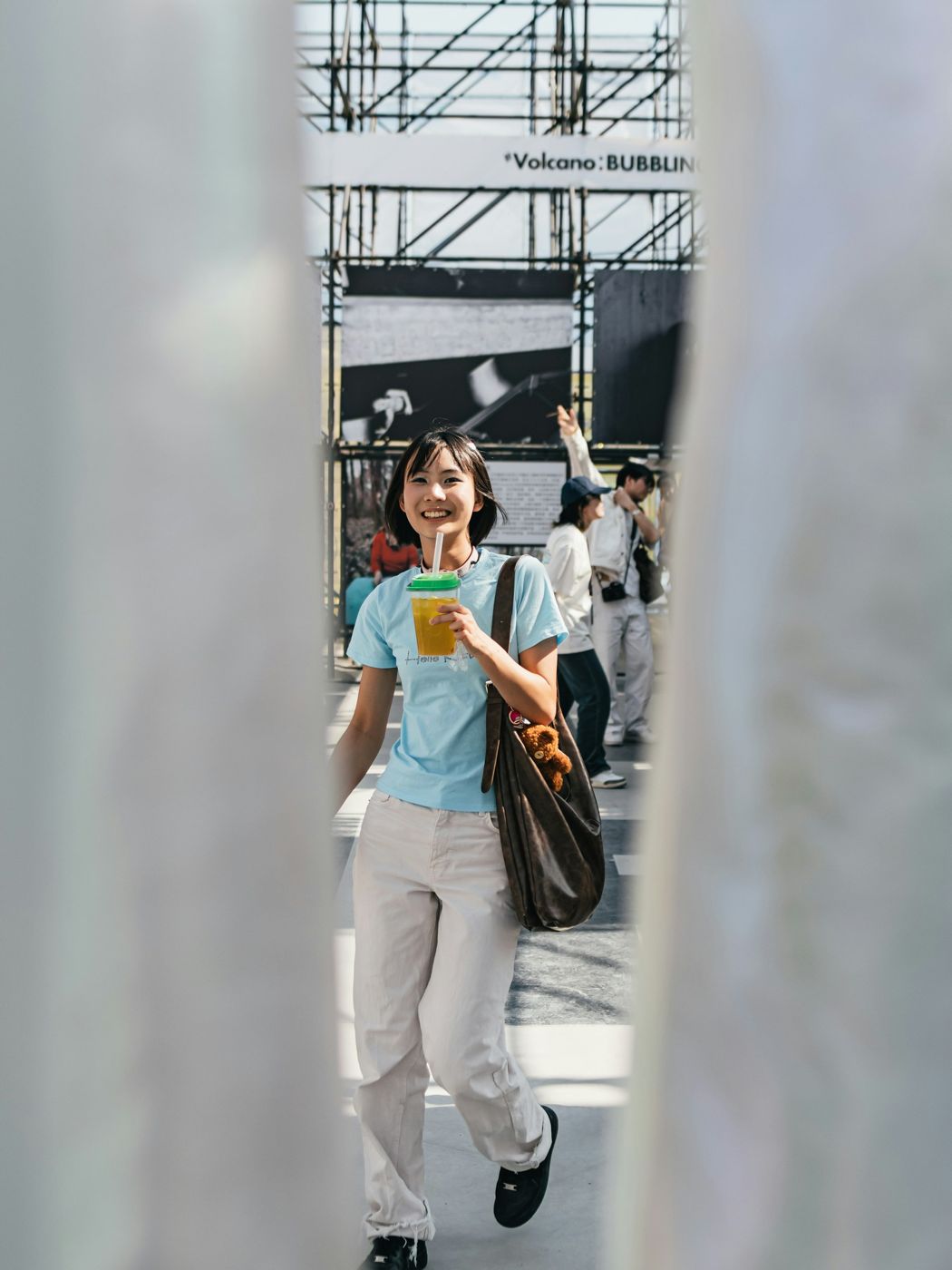 A person walking down a city street holding a coffee cup